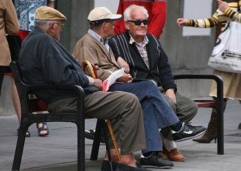 Tres jubilados descansan en el banco de un parque