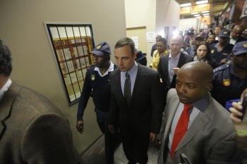 El atleta sudafricano Oscar Pistorius (c) abandona el Tribunal de la Magistratura de Pretoria.