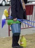 Un hombre con varios utensilios de limpieza.