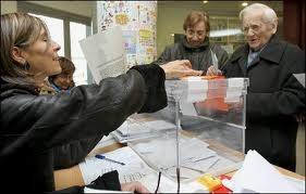 Momento en el que una mujer deposita su voto en urna.
