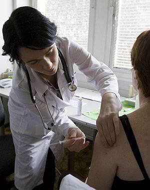 En la imagen, una mujer recibe la vacuna de la gripe.