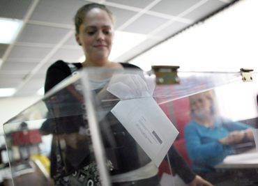 Una mujer deposita su voto en la sede del consulado en Caracas.