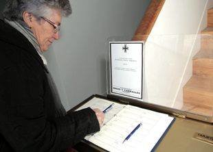 Una vecina de Vilalba firma en el libro de condolencias en la vivienda familiar de Manuel Fraga.