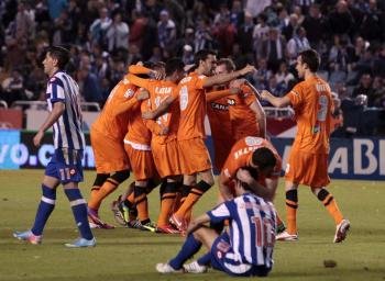 Los jugadores de la Real Sociedad celebran su victoria ante Riki y Juan Domínguez, desolados.