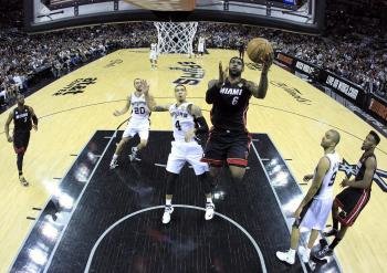 El jugador de los Heat LeBron James (centro dcha) salta para encestar ante la mirada de Danny Green (centro) de los spurs durante el partido de la serie final de la NBA (Foto: efe)