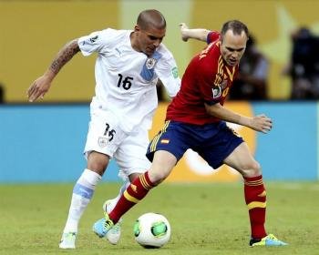  El centrocampista de la selección española Andrés Iniesta (d) pelea un balón con Maximiliano Pereira, de Uruguay