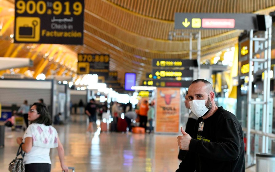 GRAF7122. MADRID, 15/03/2020.- Pasajeros se protegen con mascarillas en la terminal 4 del aeropuerto Adolfo Suarez Madrid Barajas, este domingo. EFE/ Víctor Lerena