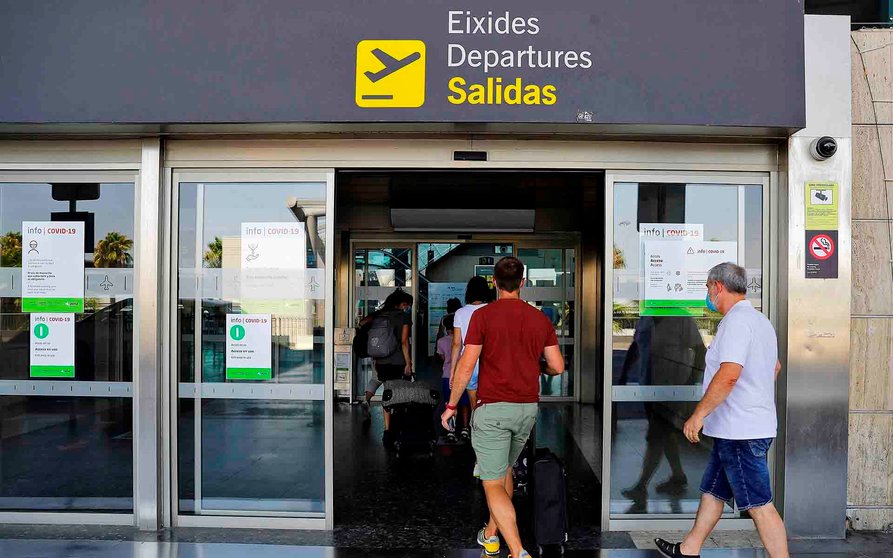 Varios viajeros acceden, este domingo, al aeropuerto de Manises. EFE/Manuel Bruque
