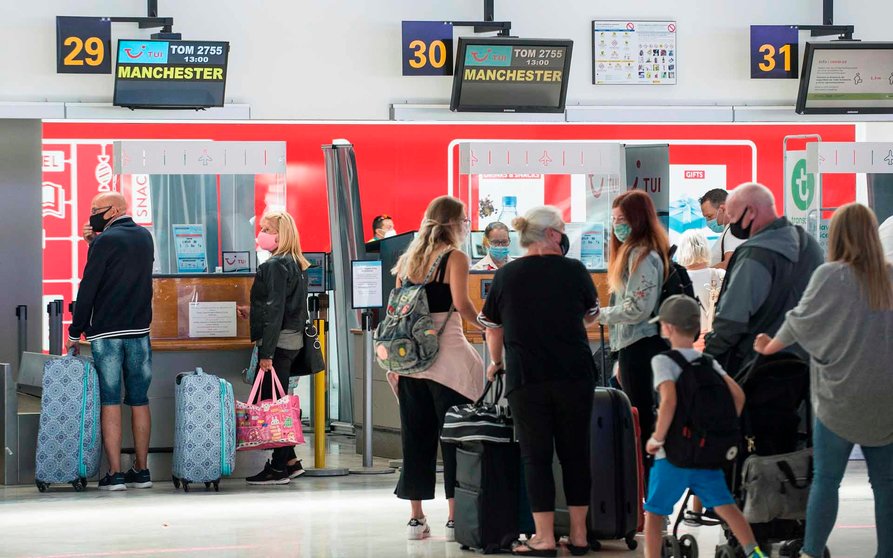 Travelers heading to Machester, UK, queue up at the check-in in San Bartolome airport in Lanzarote, Canary Islands, Spain, 26 July 2020, on the first day that the UK has imposed a surprise 14-day quarantine again to those people arriving from Spain due to a surge in coronavirus cases. EFE/ Javier Fuentes Figueroa
