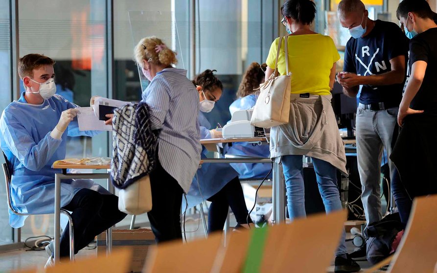 Pasajeros esperan su turno para hacerse un test de coronavirus en el aeropuerto de Dortmund, Alemania. EFE/EPA/FRIEDEMANN VOGEL
