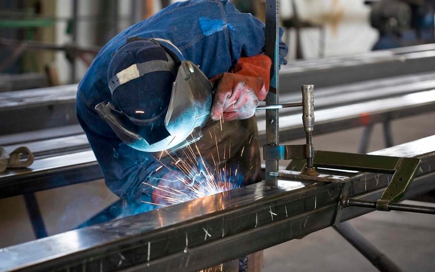 Industry worker welding steel in a factory