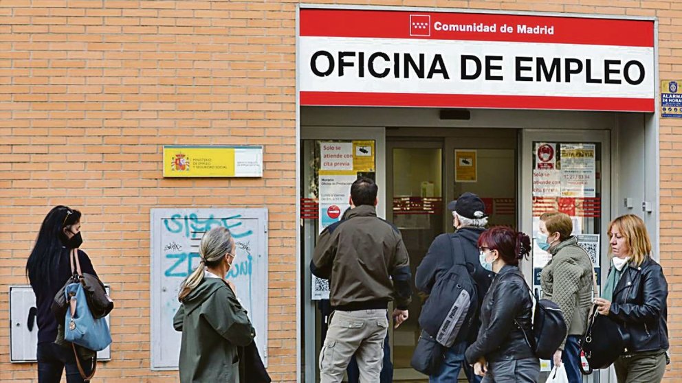 Un grupo de trabajadores hace cola en una oficina de empleo de Madrid. 