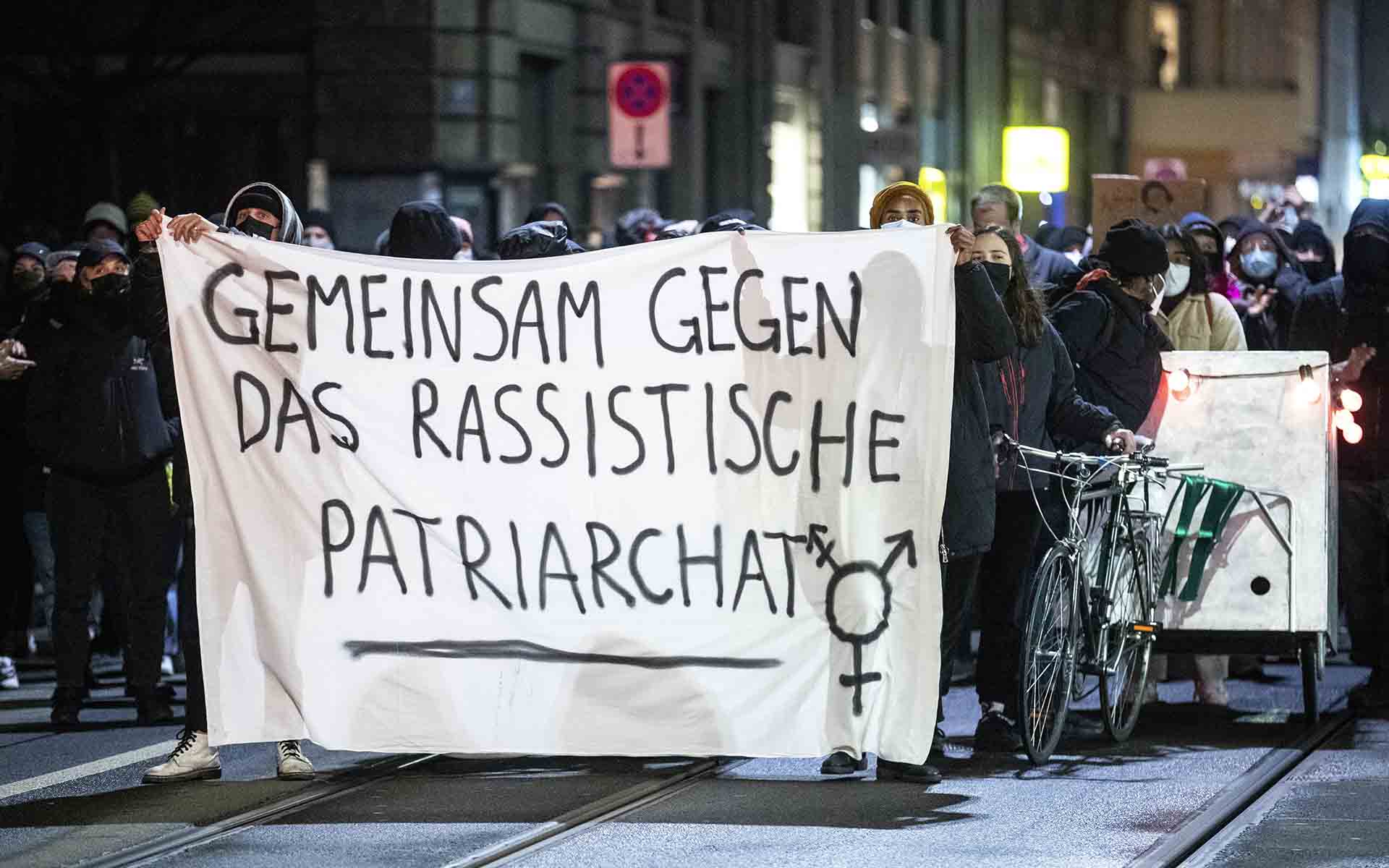 Zürich (Switzerland), 07/03/2021.- Demonstrators hold a banner with the words 'together against racist patriarchy' in a protest after the Burqa ban referendum was narrowly accepted by the electorate, in Zurich, Switzerland, 07 March 2021. Swiss citizens voted on a proposal to prohibit the concealment of one's face in the public space. Led by right-wing groups, the so-called 'anti-burqa' initiative provides for a ban on the wearing of the niqab, as well as other non-religious forms of face concealment. The referendum provisional official results showed the ban passed by a 51.2 to 48.8 percent margin. (Protestas, Suiza) EFE/EPA/ALEXANDRA WEY
